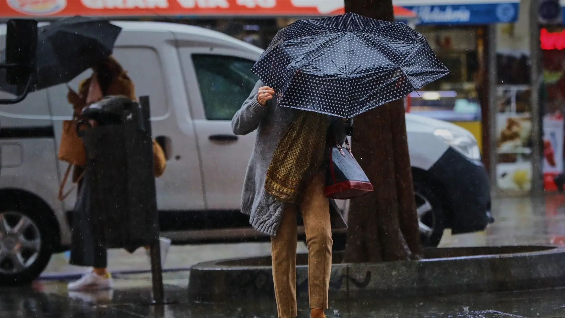 Una persona camina por el centro de la capital en una jornada marcada por las lluvias.
