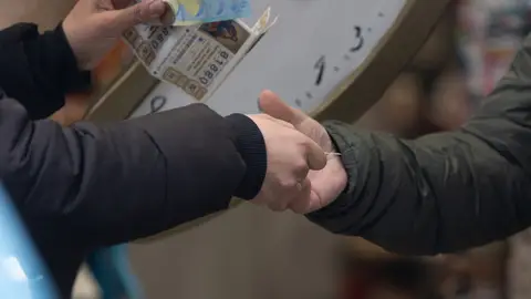 Una persona compra Lotería de Navidad, en Madrid (España). Una persona compra Lotería de Navidad, en Madrid (España).
