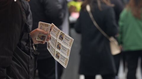 Una persona con varios décimos de Lotería de Navidad