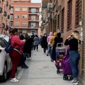 Imagen de archivo de varias personas esperando su turno para entrar al economato de Cáritas en Madrid