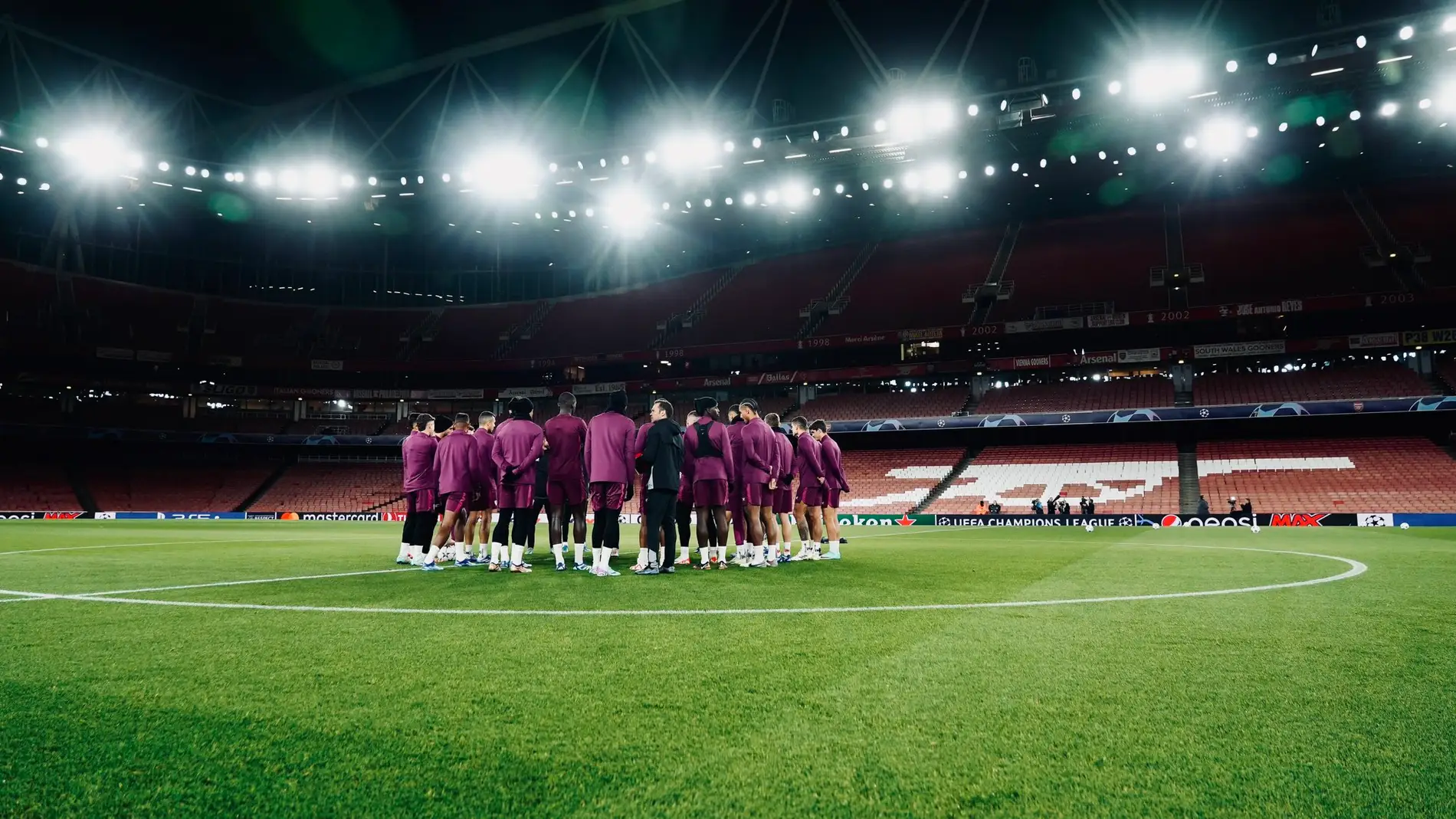 Los jugadores del Sevilla se reúnen sobre el césped del Emirates Stadium.