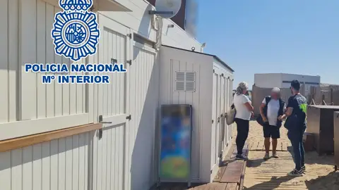 Un agente de la Policía Nacional de Elche junto al chiringuito de Los Arenales del Sol registrado. Un agente de la Policía Nacional de Elche junto al chiringuito de Los Arenales del Sol registrado.
