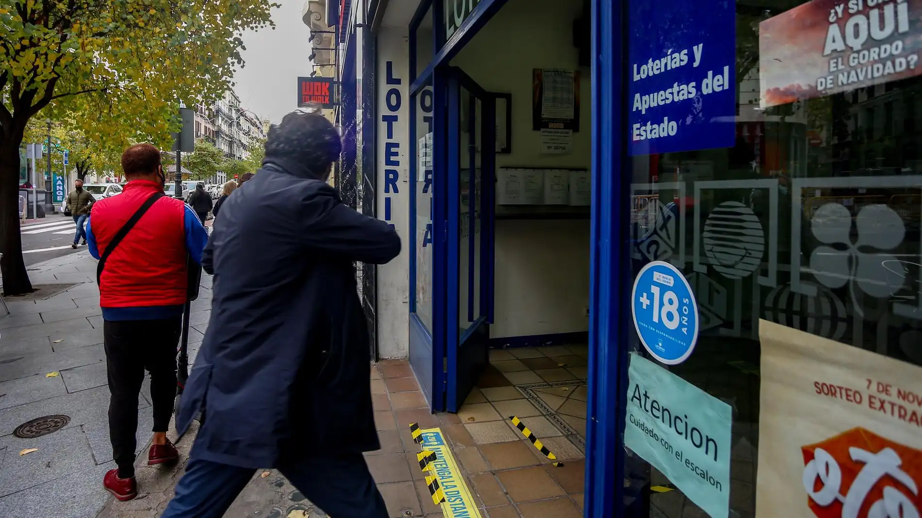 Una persona entra por la puerta de la administración de lotería Doña Manolita donde se venden boletos para el Sorteo Extraordinario de la Lotería de Navidad 2020, Madrid (España), a 4 de noviembre de 2020. A un mes y medio del tradicional sorteo 