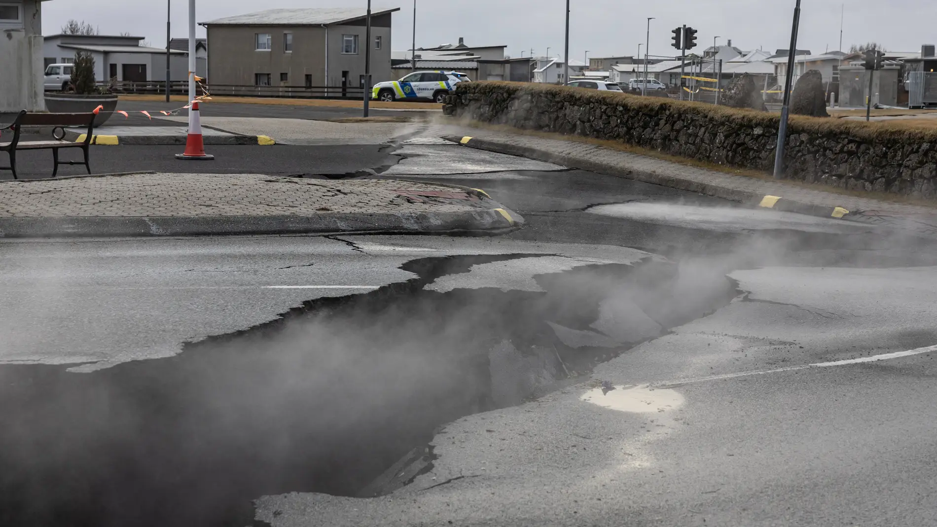 El humo sale de la grieta en una carretera en el pueblo pesquero de Grindavik, Islandia