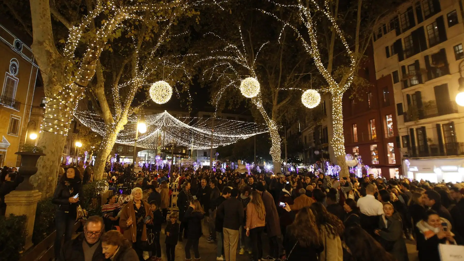 Archivo - Una multitud de personas pasea por Palma tras el encendido oficial de las luces de Navidad, en la Plaza de la Reina, en Palma de Mallorca. -