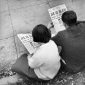Dos personas leen en el periódico la noticia del asesinato de Kennedy 