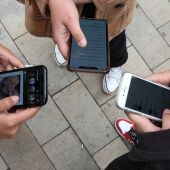 Imagen de archivo de unos jóvenes utilizando sus teléfonos móviles.