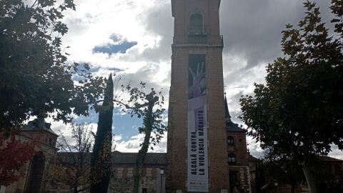 Una lona cuelga de la Torre de Santa Mar&iacute;a de Alcal&aacute; de Henares en conmemoraci&oacute;n del D&iacute;a Internacional de la Eliminaci&oacute;n de la Violencia contra la Mujer