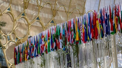 Los trabajadores ajustan banderas en Expo City Dubai