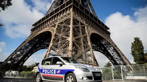 Un coche de la Policía francesa frente a la Torre Eiffel de París Un coche de la Policía francesa frente a la Torre Eiffel de París