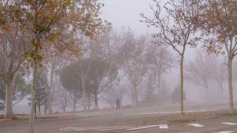 Un hombre camina entre la intensa niebla