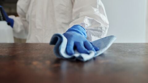 Un hombre limpiando una mesa 