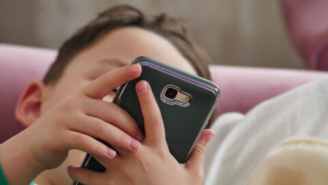 Un ni&ntilde;o con un tel&eacute;fono m&oacute;vil