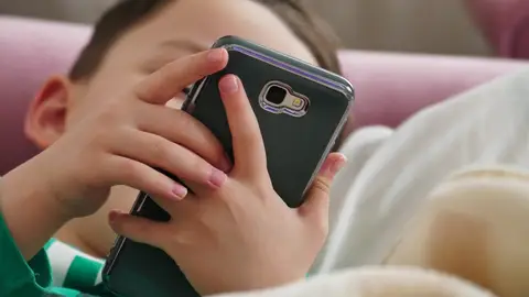 Un niño con un teléfono móvil Un niño con un teléfono móvil