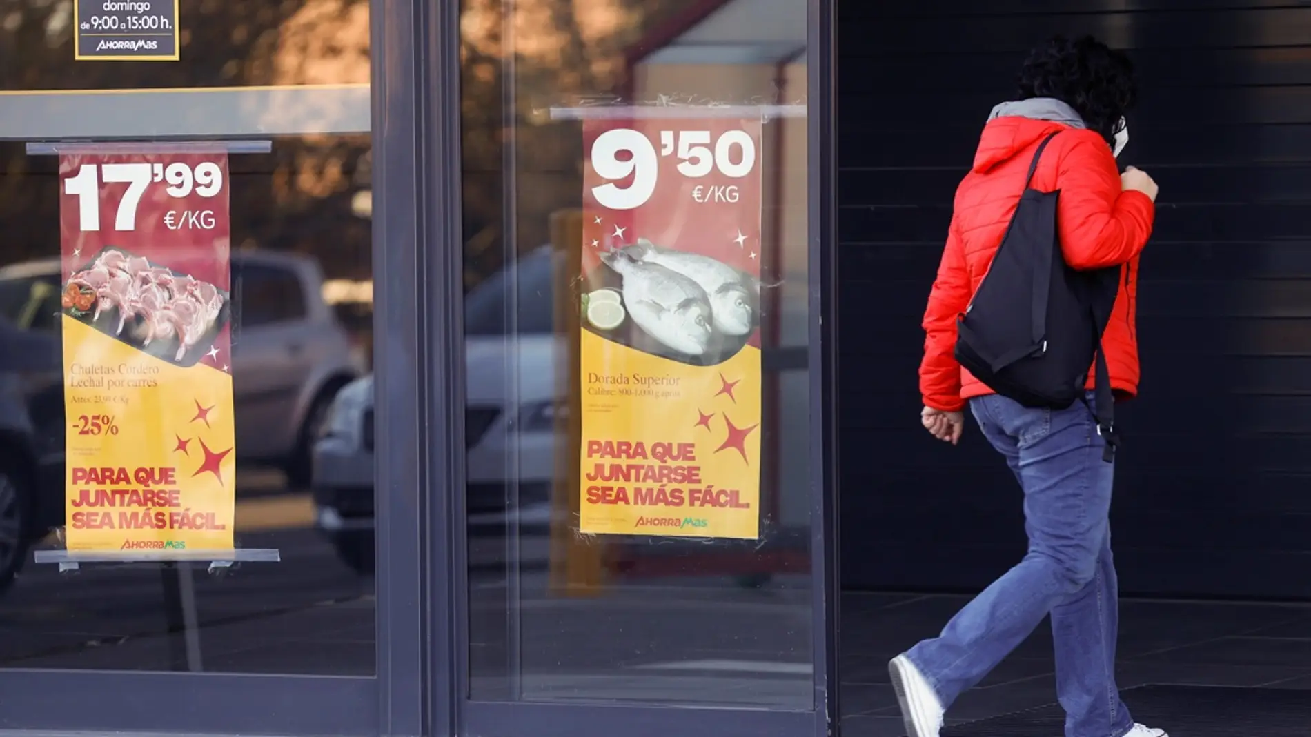 Una mujer camina frente a un supermercado en Madrid, en una imagen de archivo. / EFE/ Chema Moya