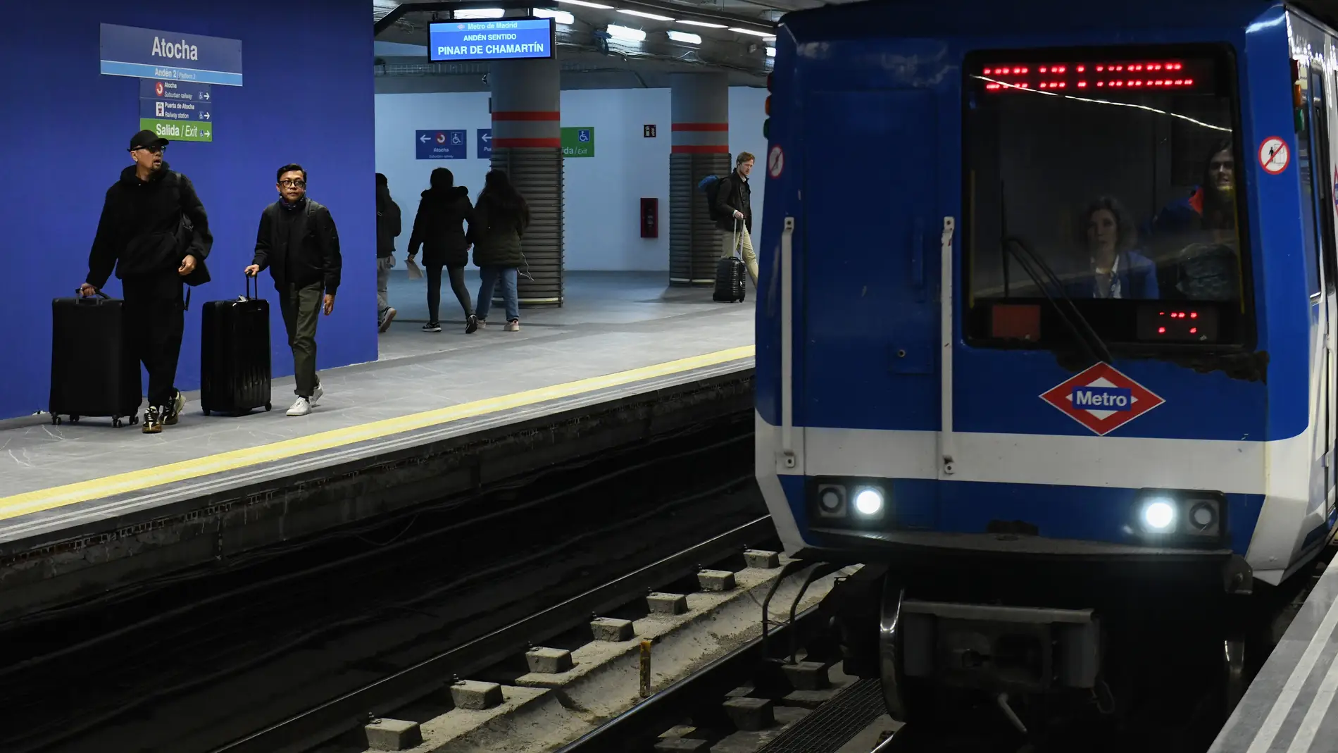 Varias personas esperan a coger la línea 1 del Metro en la estación de Atocha