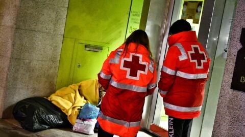 Voluntarios de Cruz Roja atendiendo a un hombre sin hogar