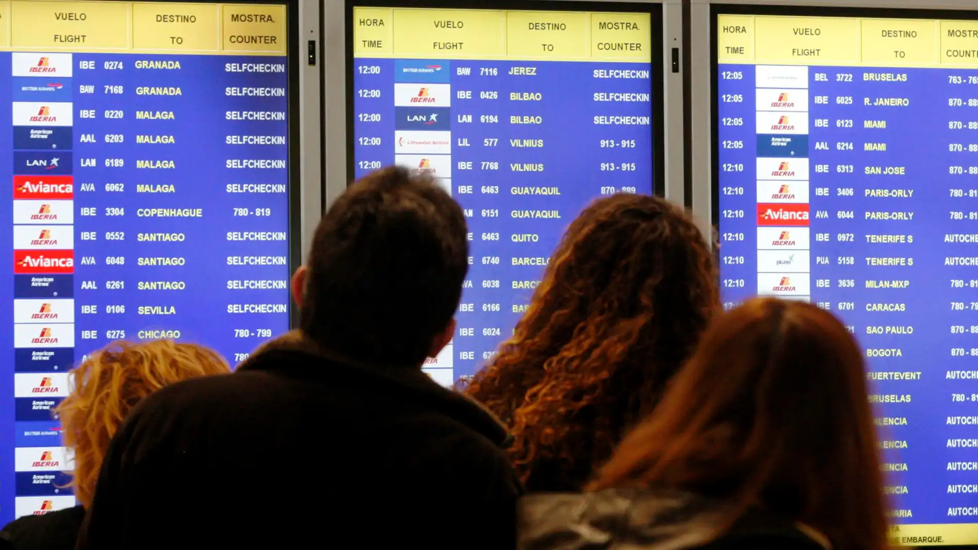 Imagen de archivo de varios viajeros consultando un panel informativo con el estado de vuelos en el aeropuerto Adolfo Suárez-Madrid Barajas.
