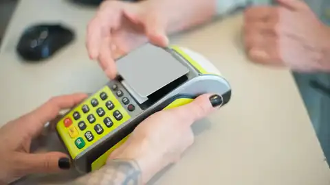 Una persona pagando con tarjeta El Banco de España alerta de los riesgos de no pedir la copia al pagar en un local