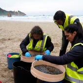 Operarios retiran los pellets o bolitas para fabricar plástico que aparecen en las playas de Asturias