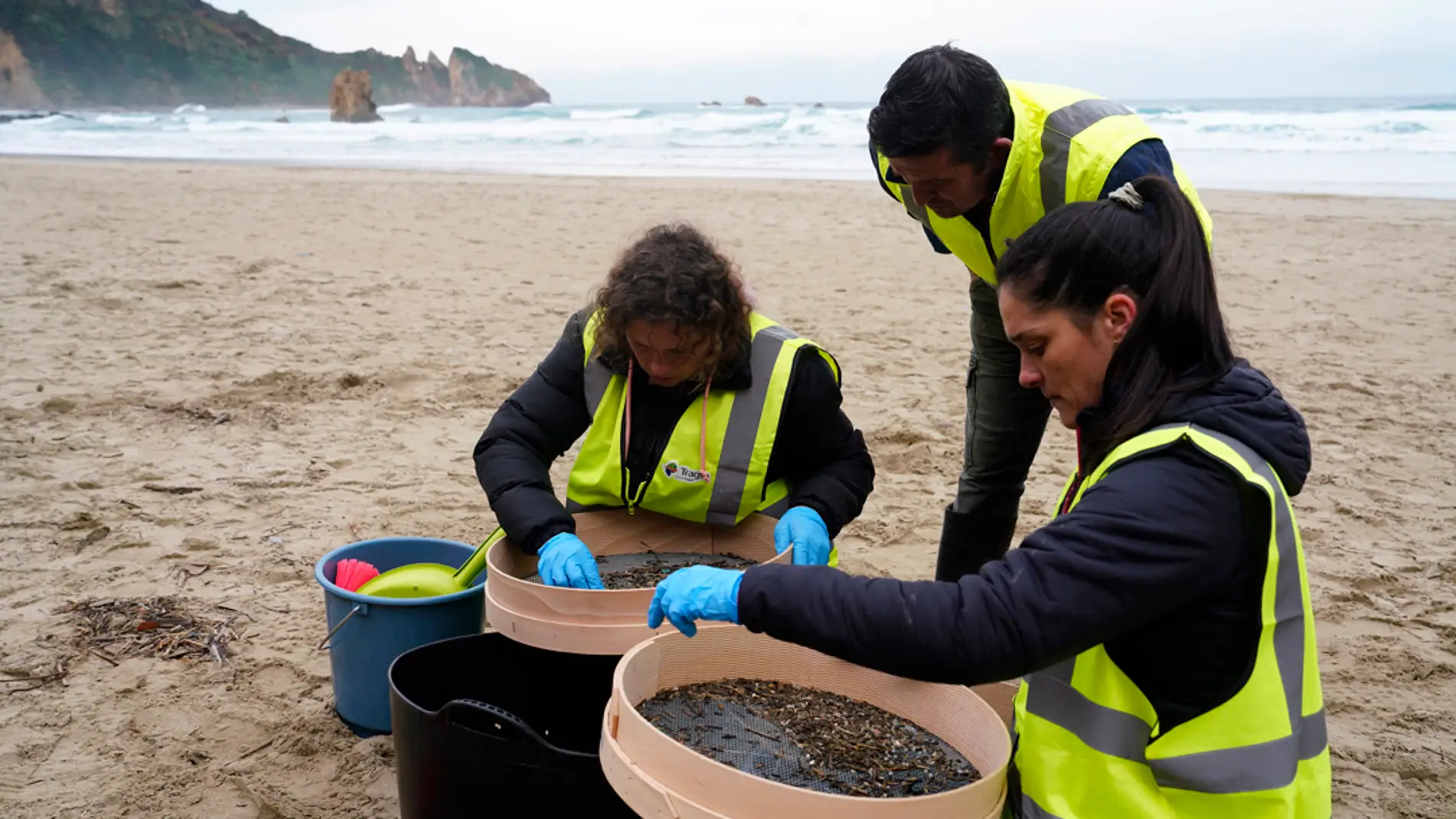 Operarios retiran los pellets o bolitas para fabricar plástico que aparecen en las playas de Asturias/ EFE/Paco Paredes