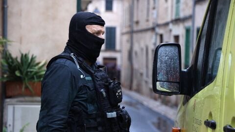 Un agente de la Guardia Civil junto a una ambulancia durante el operativo desarrollado en S&oacute;ller, donde un hombre se hab&iacute;a atrincherado en su casa con un cuchillo y dos ballestas