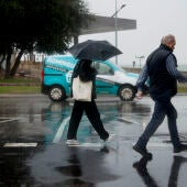 Dos personas caminan bajo la lluvia en Toledo