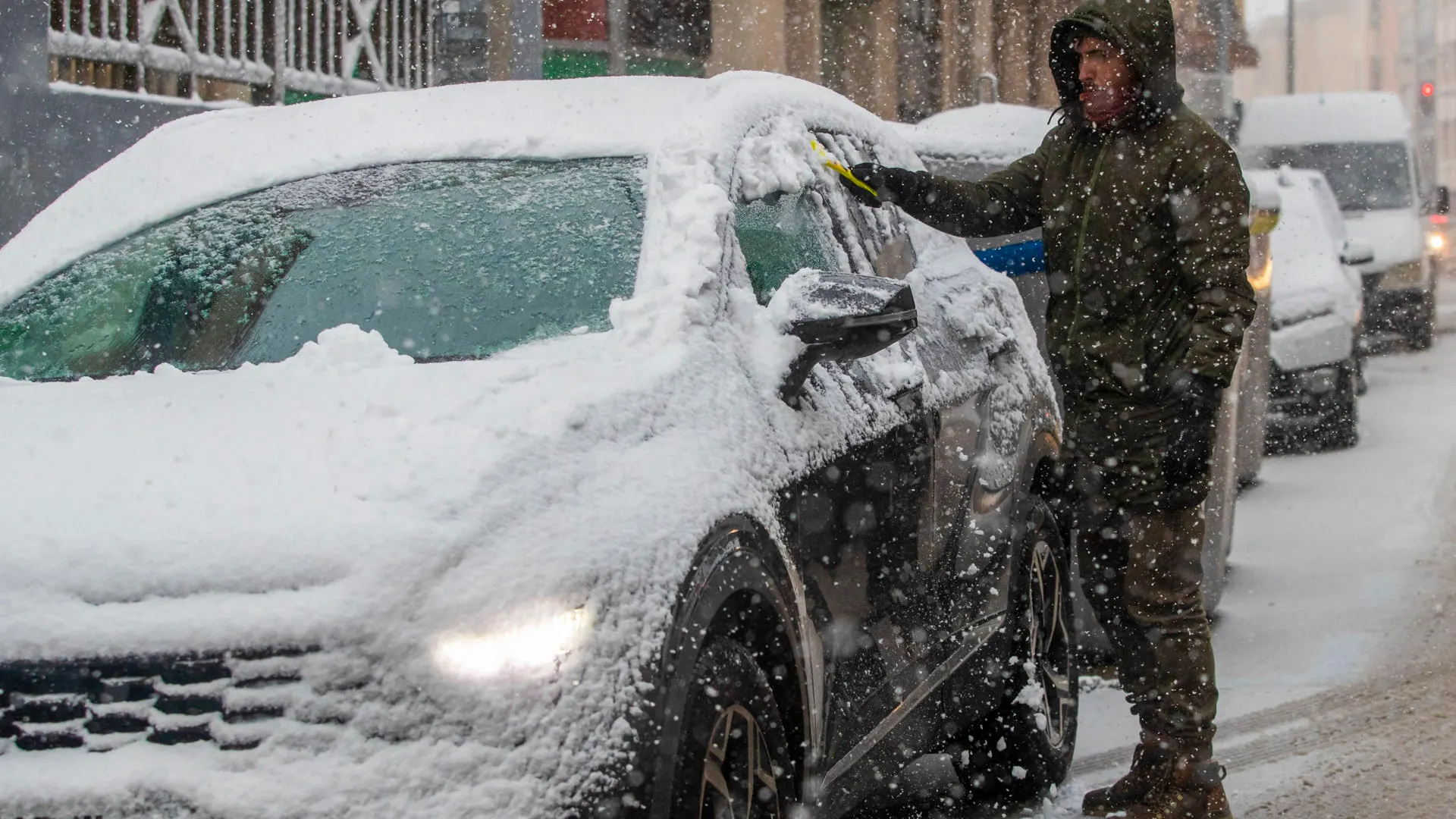 Un hombre retira la nieve de un vehículo durante la nevada en Soria. Un hombre retira la nieve de un vehículo durante la nevada en Soria.
