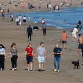 Un gran número de personas disfrutan del buen tiempo en la playa de la Malvarrosa.