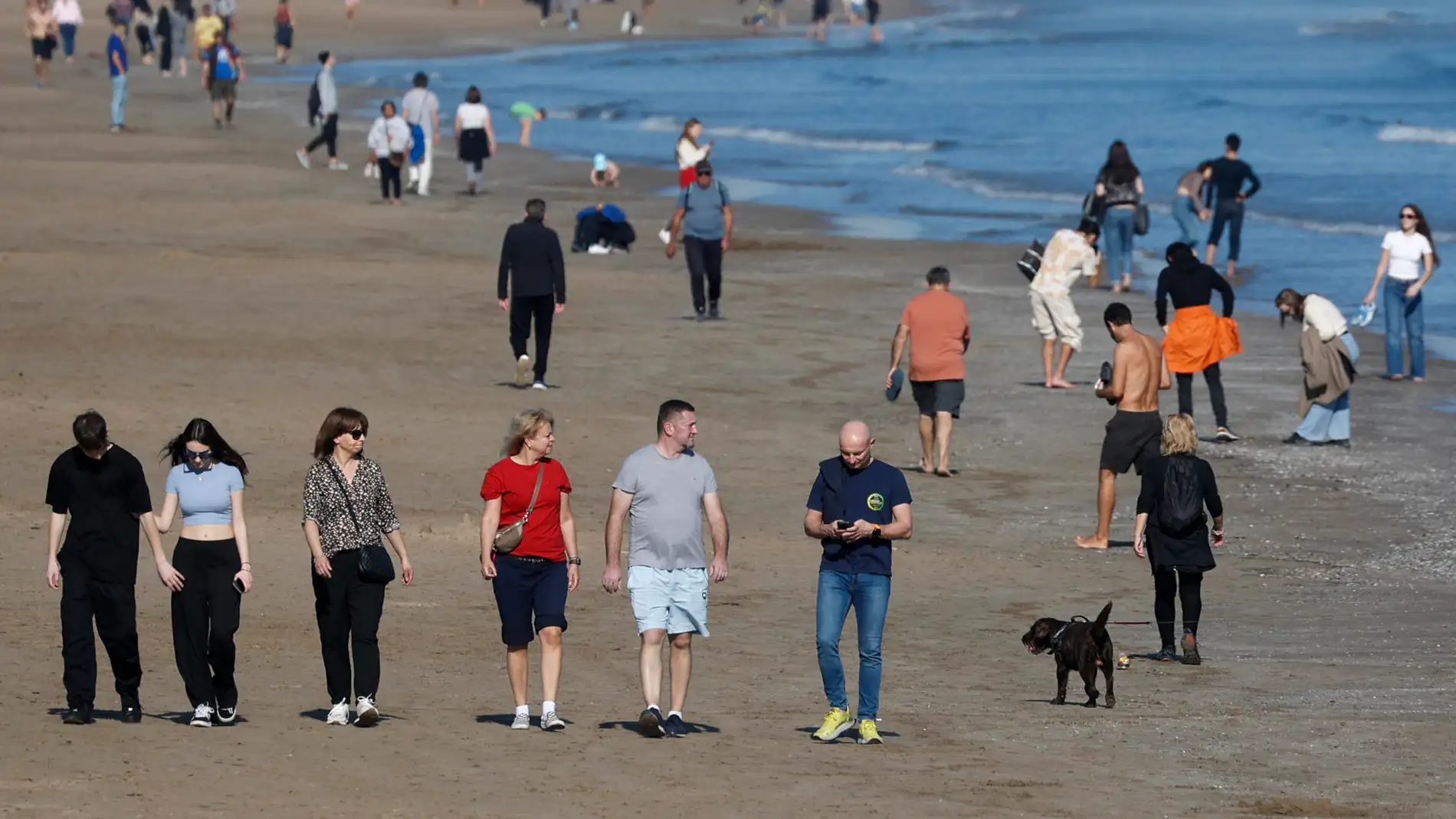 Un gran número de personas disfrutan del buen tiempo en la playa de la Malvarrosa.