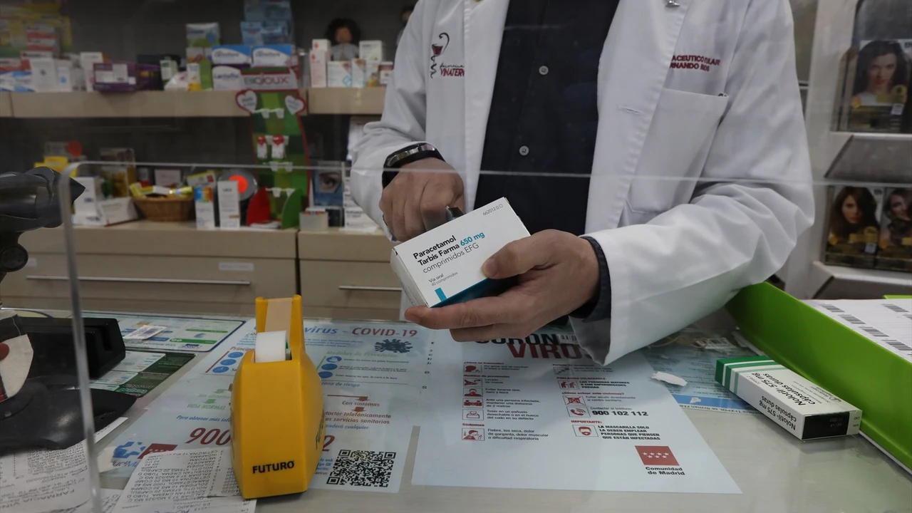 Un farmacéutico recorta el código de barras de una caja de Paracetamol en su farmacia.