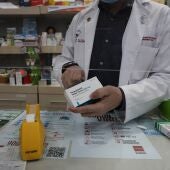 Un farmacéutico recorta el código de barras de una caja de Paracetamol en su farmacia.