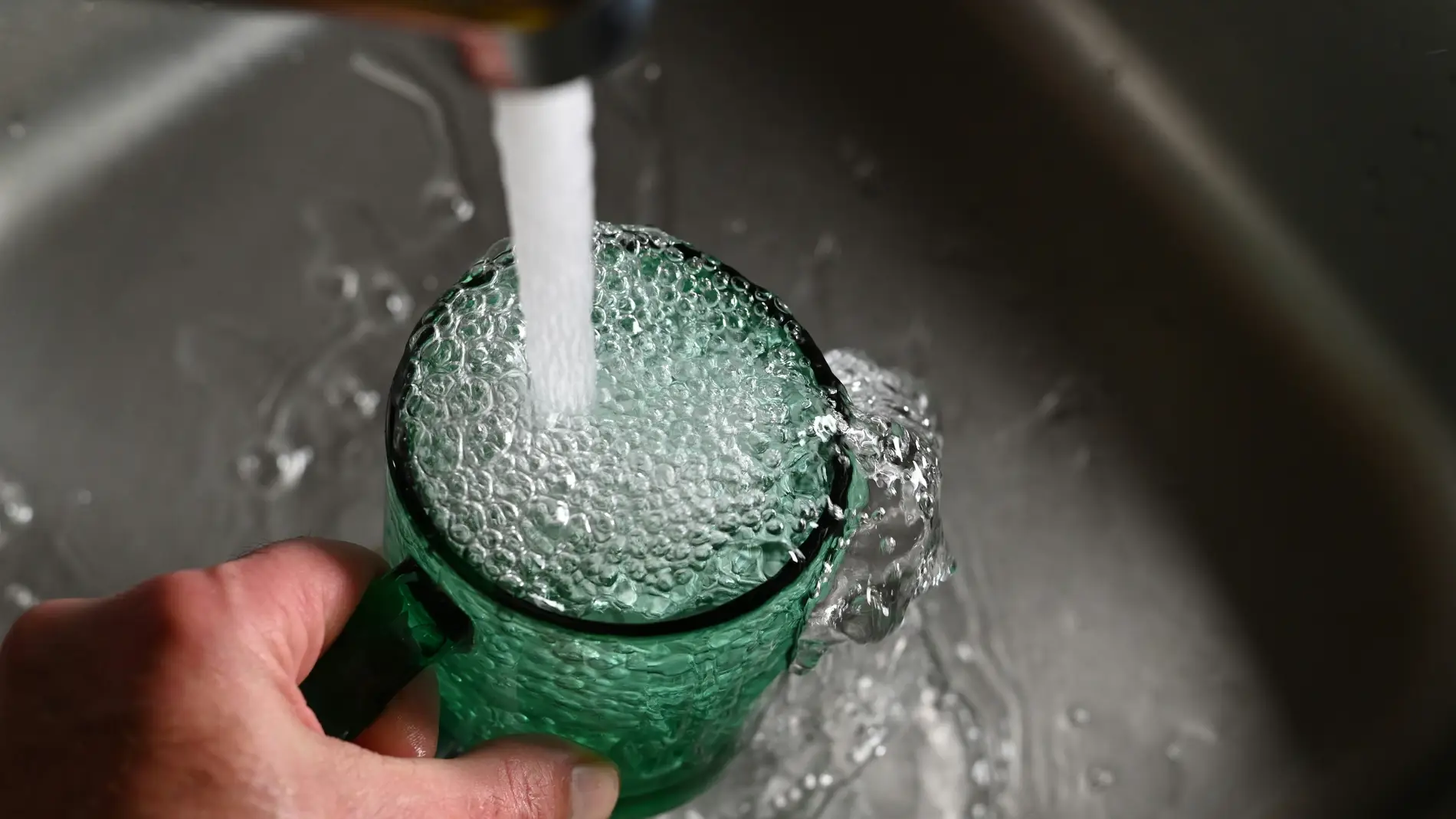 Imagen de archivo de una persona lavando un vaso.