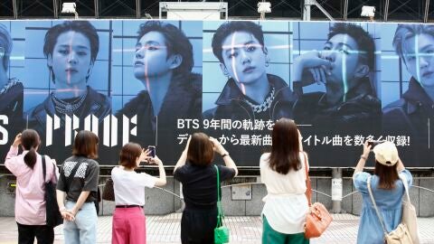 Fans del pop japon&eacute;s delante de un cartel con sus &iacute;dolos