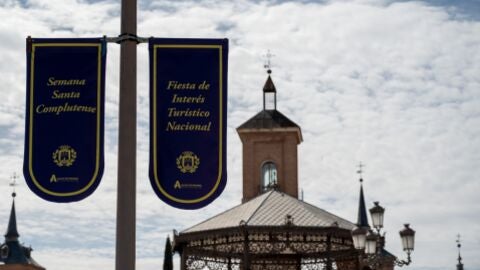 Farola de la Plaza de Cervantes de Alcal&aacute; engalanada con los carteles anunciadores de la Semana Santa complutense, Fiesta de Inter&eacute;s Tur&iacute;stico Nacional