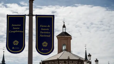 Las obras en el casco histórico alcalaíno obligan a cambiar los recorridos de algunas hermandades durante esta Semana Santa Farola de la Plaza de Cervantes de Alcalá engalanada con los carteles anunciadores de la Semana Santa complutense, Fiesta de Interés Turístico Nacional