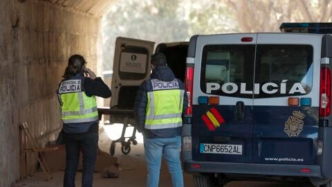 Dos agentes de la Policía Nacional aguardan bajo el Puente del Real en el lugar donde se ha encontrado a dos hombres muertos 