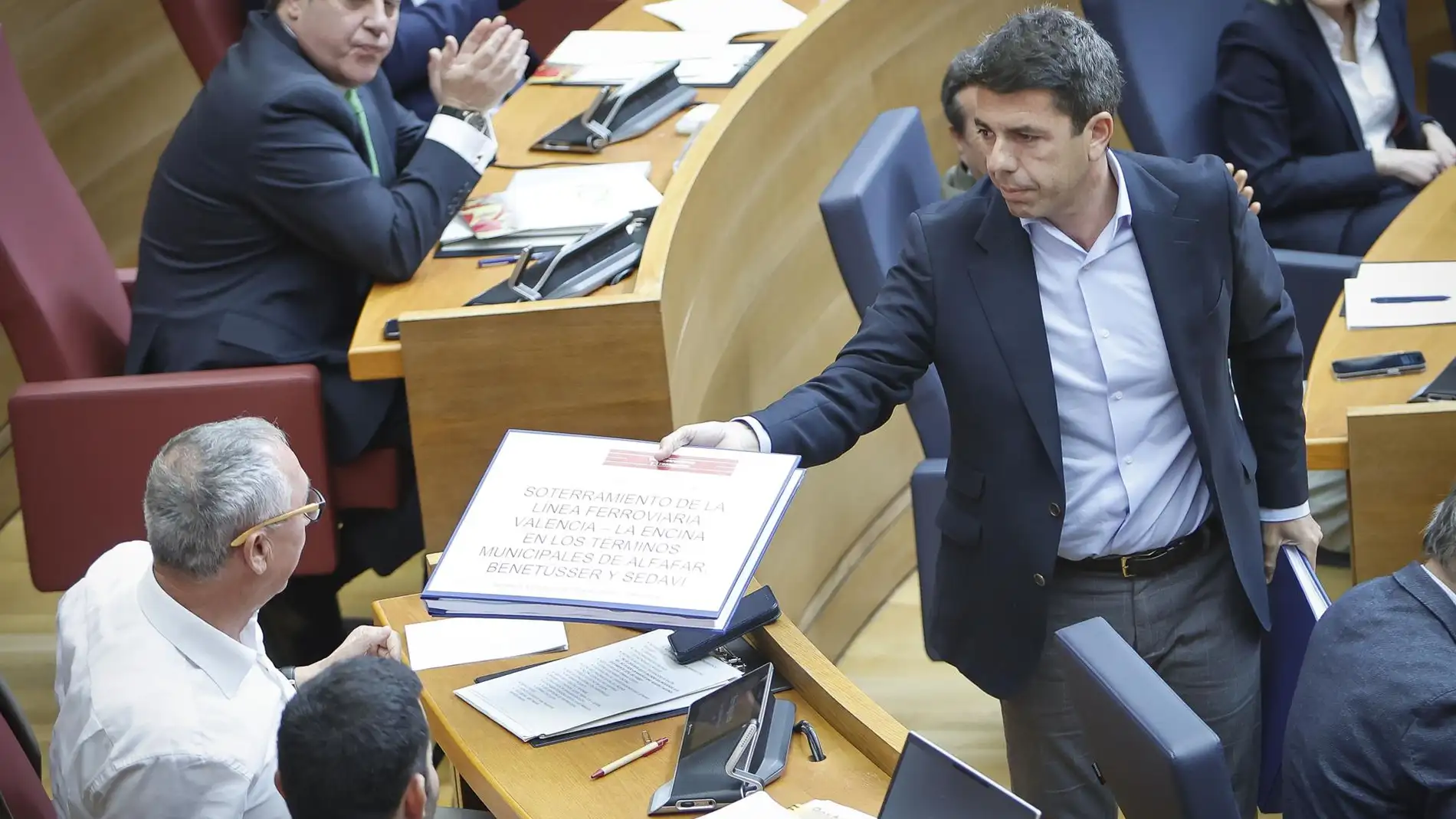 El 'president' Carlos Mazón entrega un documento a Joan Baldoví (Compromís) en la sesión de control en Les Corts - 