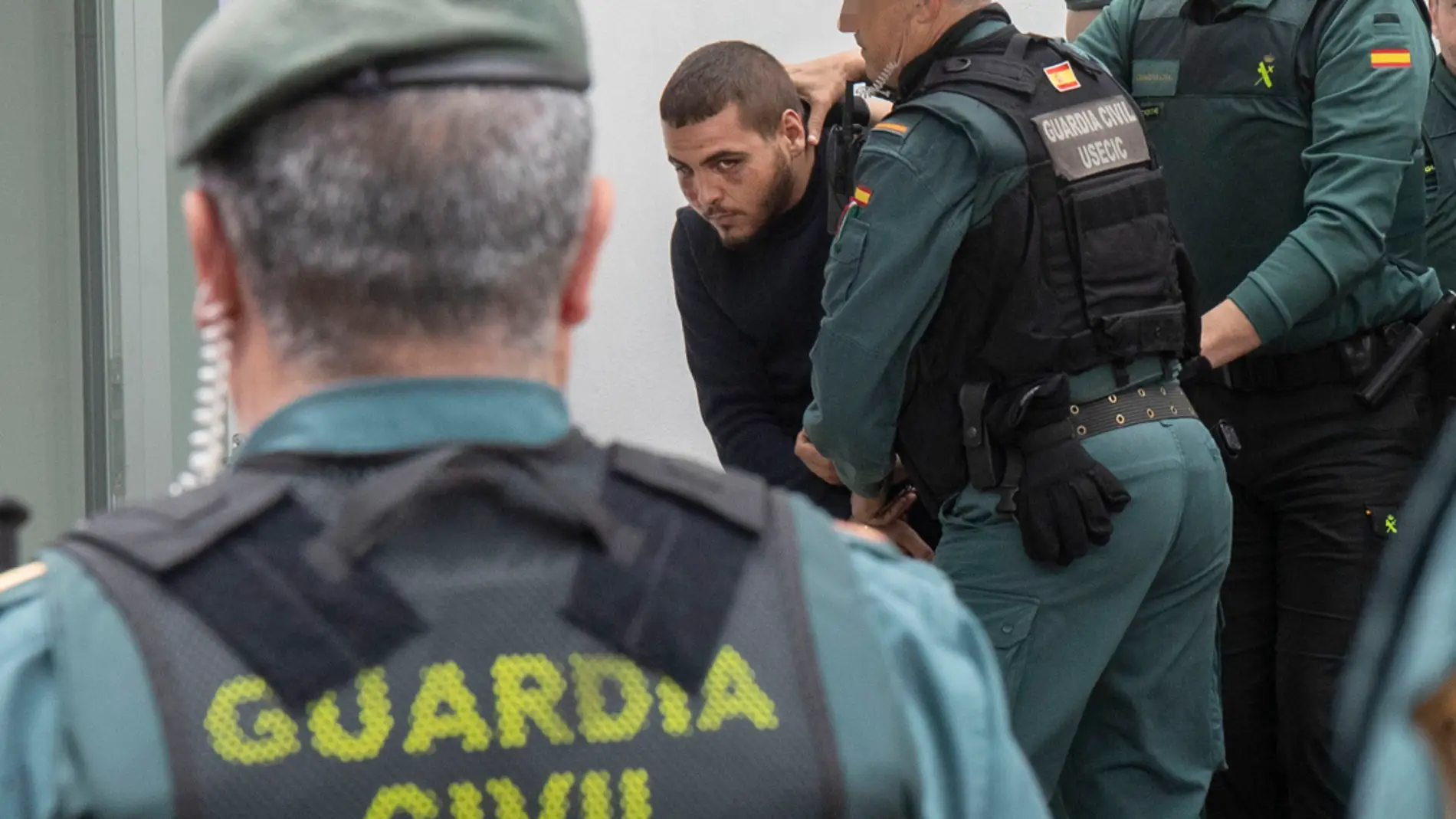 Agentes de la Guardia Civil trasladan a los juzgados de Barbate (Cádiz) a uno de los ocho detenidos por la muerte de dos guardias civiles/ EFE/Román Ríos.