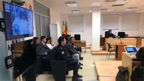 El acusado ante el tribunal, escoltado por agentes de la Polic&iacute;a Nacional