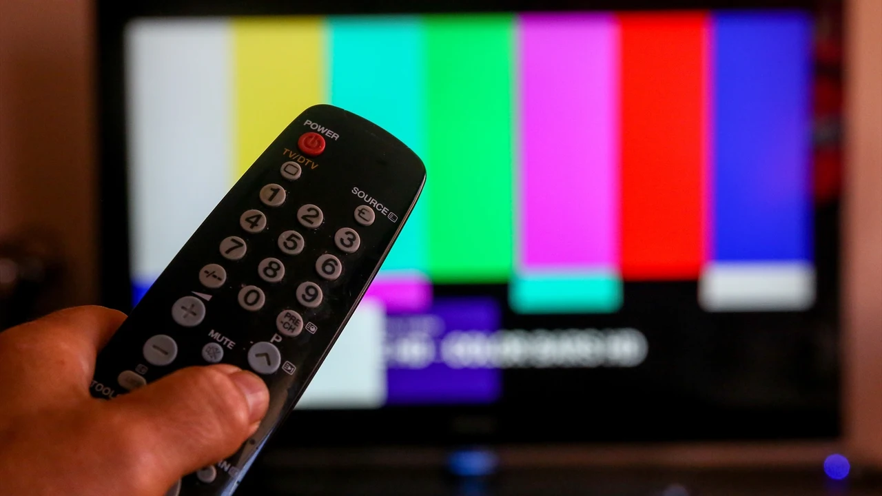 Una persona utiliza su mando de la televisión para buscar canales