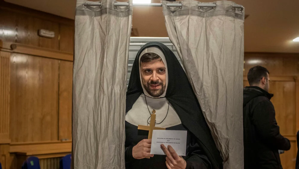 Una persona disfrazada vota en un colegio electoral en Xinzo de Limia (Ourense)