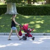 Una persona pasea con un carrito de bebé en el parque de El Retiro, a 29 de julio de 2023