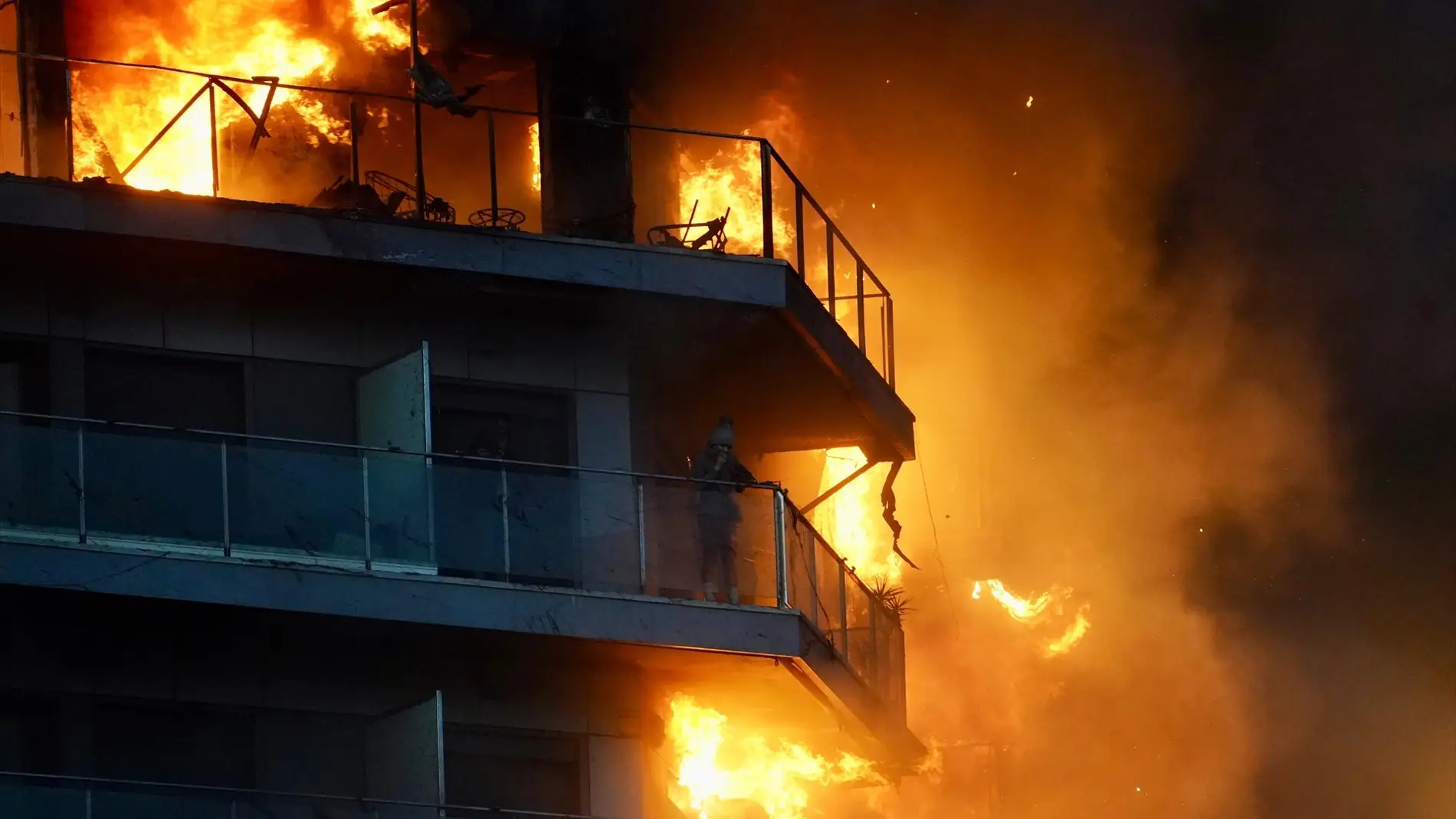 Una persona en un balcón del edificio en llamas, en el barrio de Campanar.