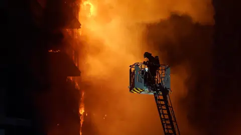 Un bombero realiza trabajos para apagar el incendio de un edificio de pisos en Valencia Un bombero realiza trabajos para apagar el incendio de un edificio de pisos en Valencia