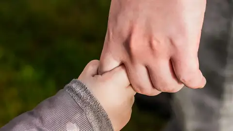 Niño de la mano de un adulto | Imagen de archivo Niño de la mano de un adulto | Imagen de archivo
