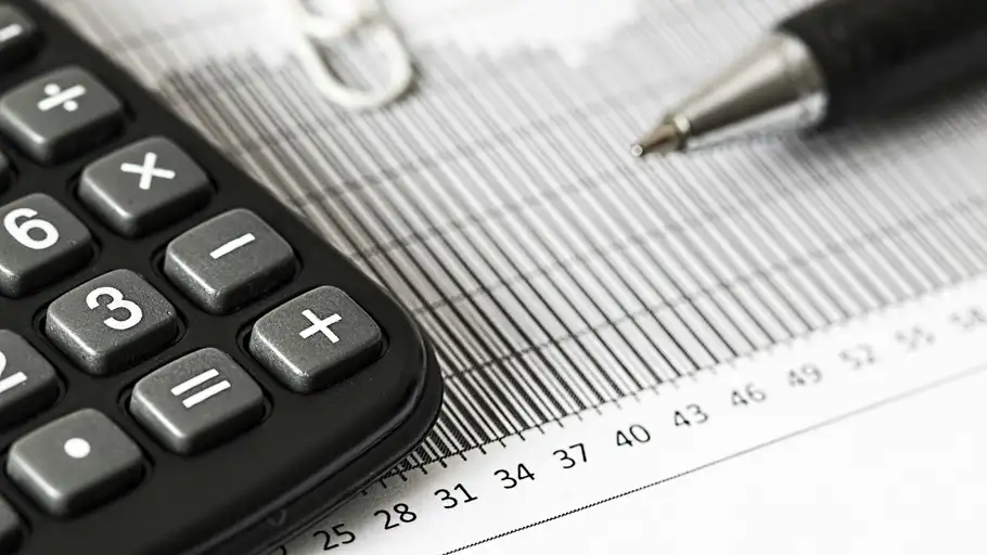 Una calculadora y unos documentos de impuestos Una calculadora y unos documentos de impuestos
