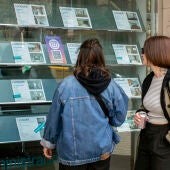 Dos personas observan la oferta de pisos en alquiler de una oficina inmobiliaria de Barcelona 