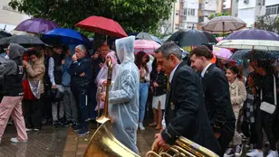 Músicos de la Hermandad del Cautivo de San Pablo ( Sevilla) se marchan tras suspenderse por la lluvia su estación de penitencia