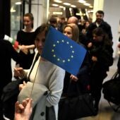 Una persona entrega banderas de la UE a los pasajeros que llegan en un vuelo procedente de Berlín durante la apertura simbólica del espacio Schengen en el aeropuerto de Sofía, Bulgaria, el 31 de marzo de 2024.